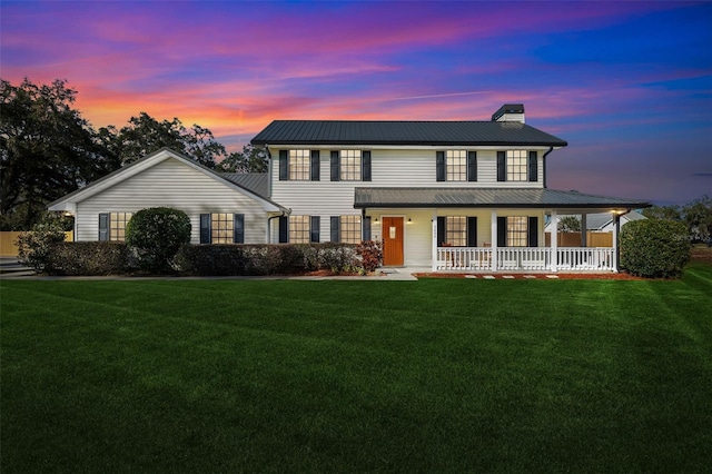 view of front of property with a porch and a lawn