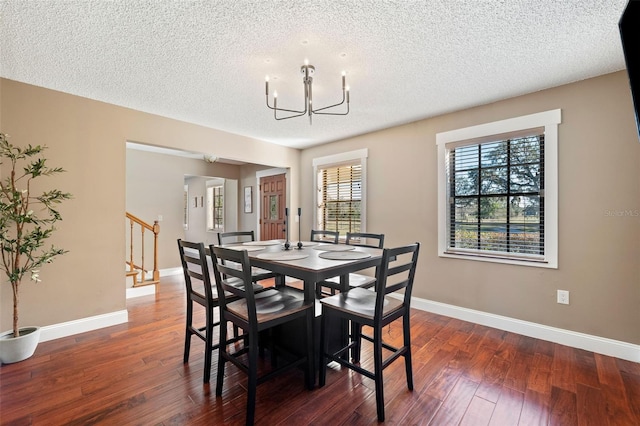 dining area featuring an inviting chandelier, dark hardwood / wood-style floors, and a textured ceiling