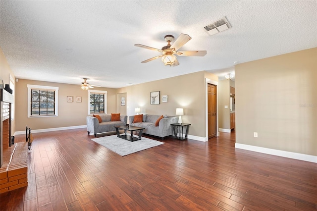 living room featuring dark hardwood / wood-style flooring, a textured ceiling, and ceiling fan