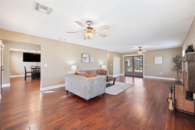 living room featuring dark hardwood / wood-style floors, a fireplace, ceiling fan, and french doors