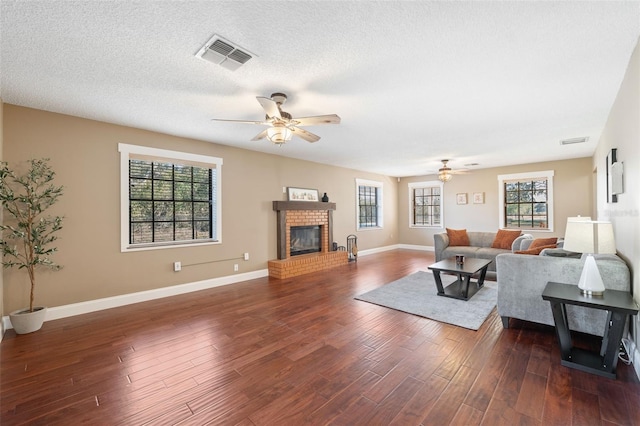 living room with ceiling fan, dark hardwood / wood-style floors, a wealth of natural light, and a fireplace