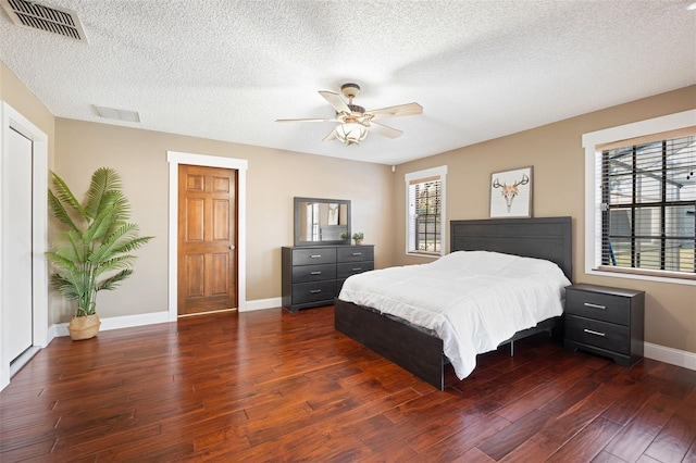 bedroom featuring a textured ceiling, dark hardwood / wood-style floors, and ceiling fan