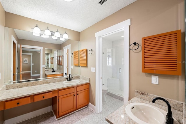 bathroom featuring walk in shower, vanity, toilet, and a textured ceiling