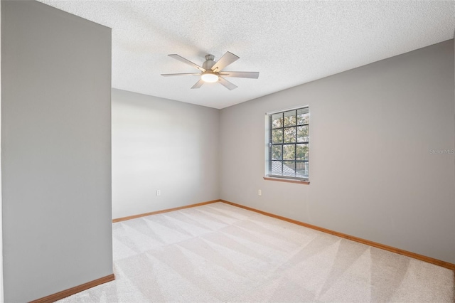 carpeted empty room with ceiling fan and a textured ceiling