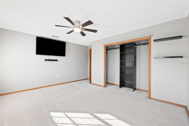 unfurnished bedroom featuring ceiling fan, light carpet, and a closet