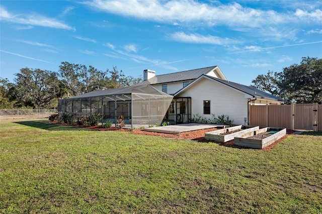 rear view of house with a lanai and a lawn