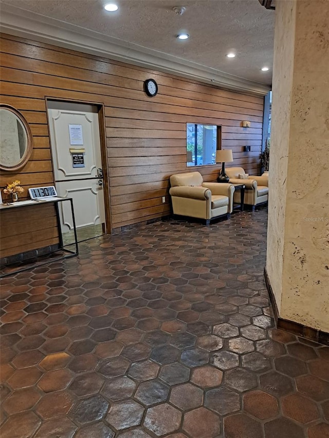 interior space with wooden walls and a textured ceiling