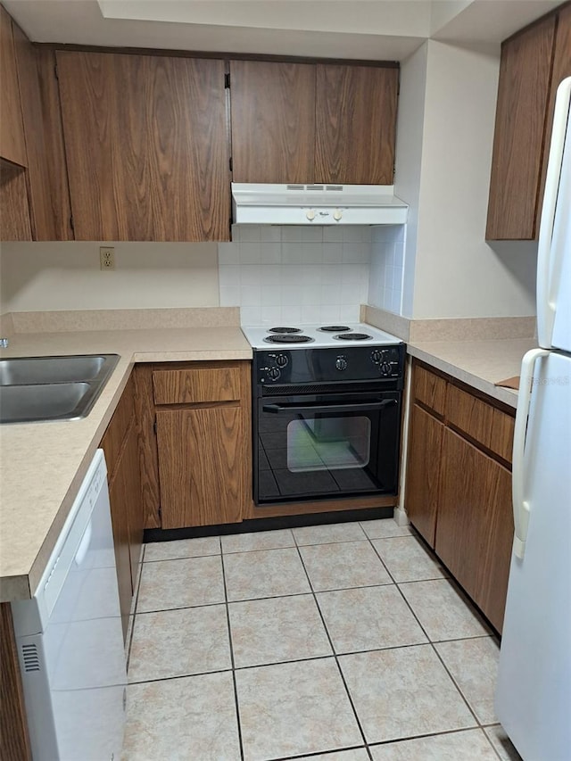 kitchen with white appliances, sink, decorative backsplash, and light tile patterned floors