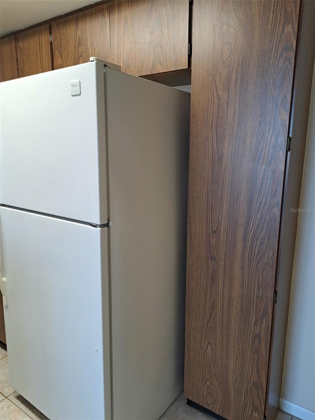 kitchen with white refrigerator and light tile patterned flooring