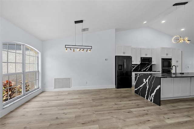 kitchen with pendant lighting, backsplash, black appliances, light hardwood / wood-style floors, and white cabinets