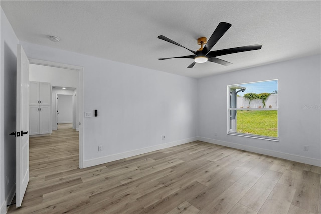 spare room featuring ceiling fan, light hardwood / wood-style flooring, and a textured ceiling