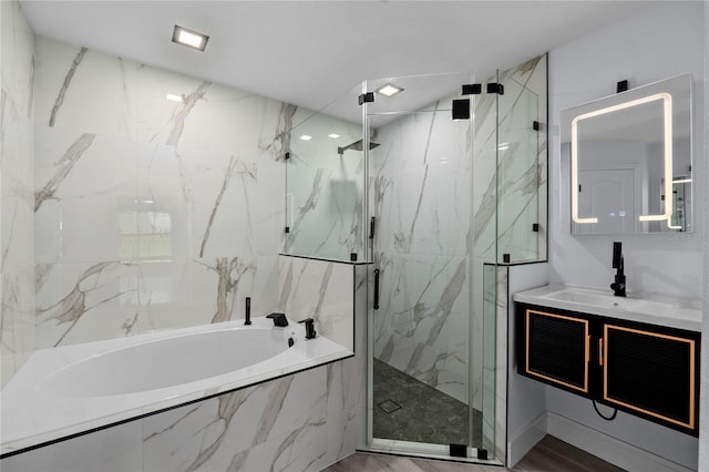 bathroom with vanity and shower with separate bathtub