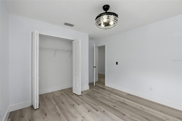 unfurnished bedroom featuring a closet and light wood-type flooring