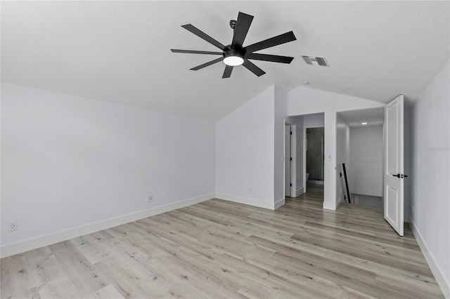 additional living space featuring ceiling fan, vaulted ceiling, a textured ceiling, and light wood-type flooring