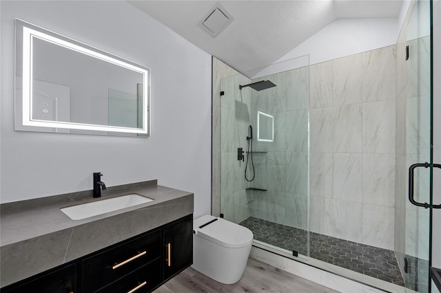 bathroom with lofted ceiling, toilet, wood-type flooring, vanity, and a shower with door