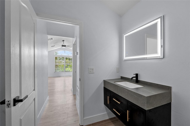 bathroom featuring hardwood / wood-style flooring, vaulted ceiling, and vanity