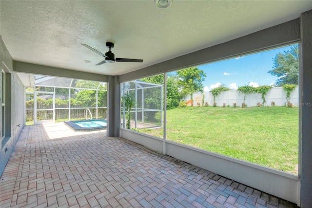 unfurnished sunroom with ceiling fan