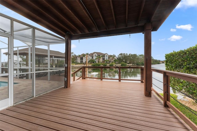 wooden terrace featuring a water view and glass enclosure