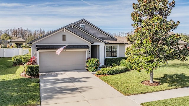 view of front of home with a garage, fence, driveway, a standing seam roof, and a front yard