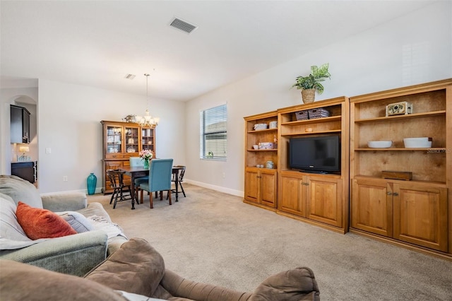 carpeted living room with an inviting chandelier