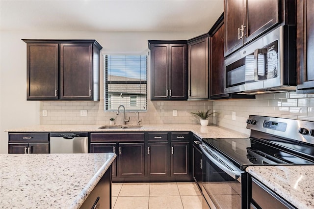 kitchen with backsplash, stainless steel appliances, sink, and light tile patterned floors