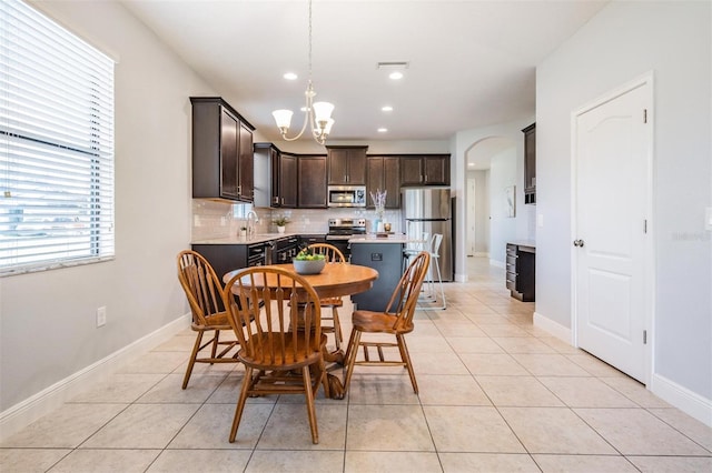 dining area with sink, a chandelier, and light tile patterned flooring