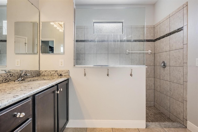 bathroom with tile patterned floors, vanity, and tiled shower