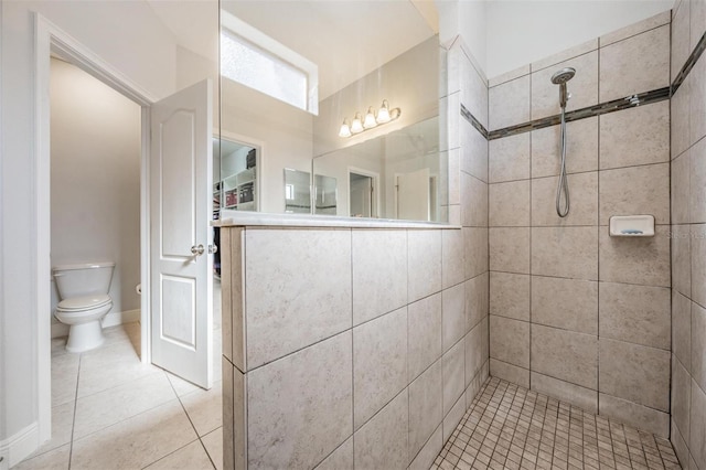 bathroom with tile patterned floors, toilet, and a tile shower