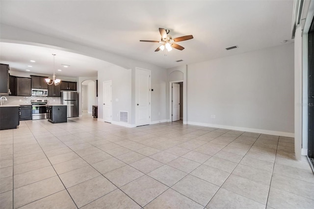 19724 Post Island Loop, Land O Lakes, FL 34638 - unfurnished living room with light tile patterned flooring, a chandelier, ceiling fan, arched walkways, and baseboards