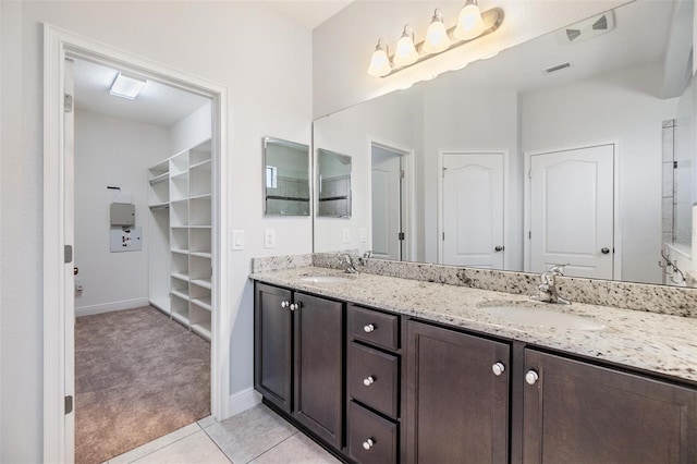 19724 Post Island Loop, Land O Lakes, FL 34638 - bathroom featuring double vanity, tile patterned floors, baseboards, and a walk in closet