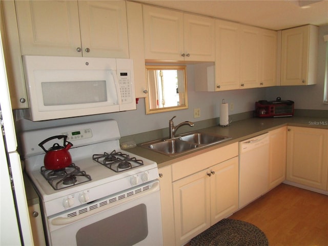 kitchen with white appliances, light hardwood / wood-style floors, and sink