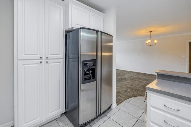 kitchen with an inviting chandelier, ornamental molding, white cabinets, light carpet, and stainless steel fridge with ice dispenser