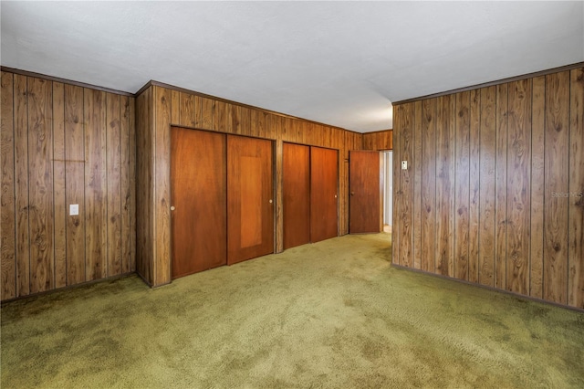 interior space featuring a closet, dark carpet, and wood walls