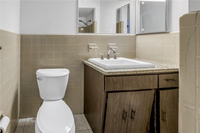 bathroom featuring tile walls, vanity, tile patterned floors, and toilet