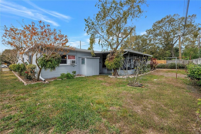 rear view of property featuring cooling unit and a yard