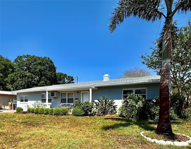 6623 16th St N, Saint Petersburg, FL 33704 - ranch-style house featuring a chimney, a front yard, a wall mounted AC, and stucco siding