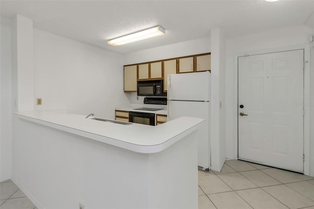 kitchen featuring sink, light tile patterned floors, range with electric cooktop, kitchen peninsula, and white fridge