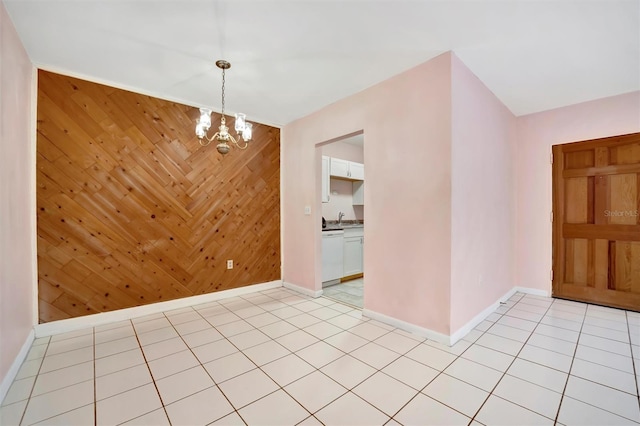 interior space featuring sink, light tile patterned floors, an inviting chandelier, and wood walls