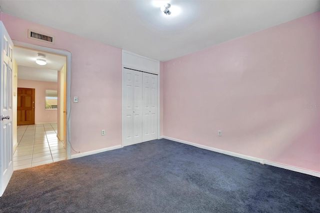 unfurnished bedroom featuring light carpet and a closet