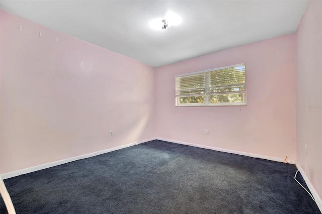 unfurnished room with dark colored carpet