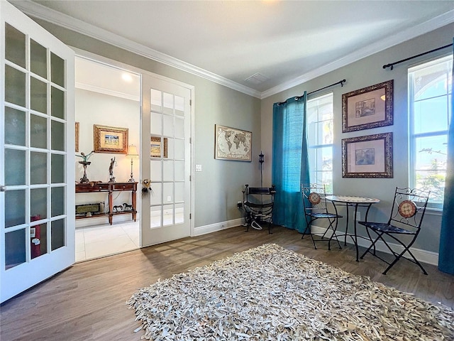 living area with hardwood / wood-style floors, crown molding, and french doors