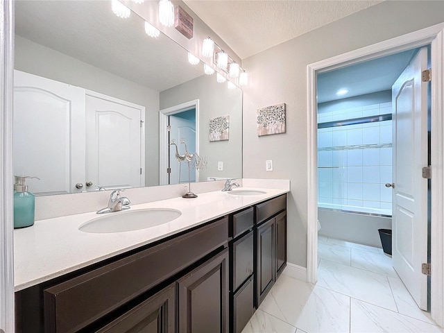 bathroom with vanity, shower / bathing tub combination, and a textured ceiling