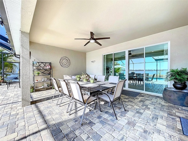 view of patio with a water view and ceiling fan