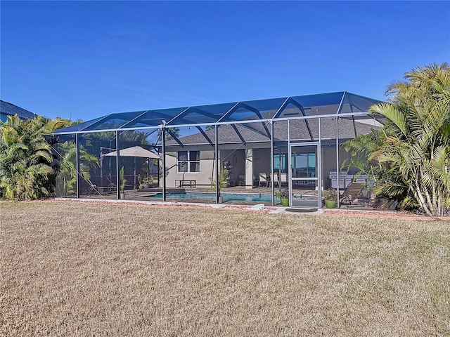 back of house with a lanai and a yard