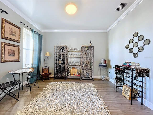 sitting room with hardwood / wood-style flooring and ornamental molding