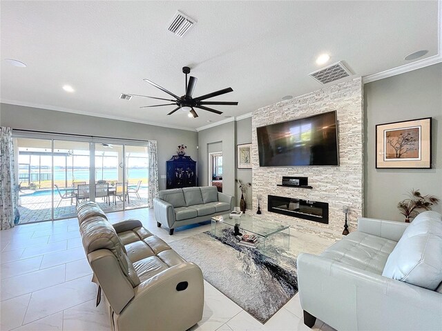 living room featuring crown molding, ceiling fan, a fireplace, and a textured ceiling