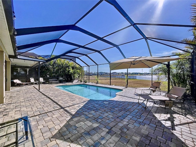 view of pool featuring a water view, a patio area, and glass enclosure