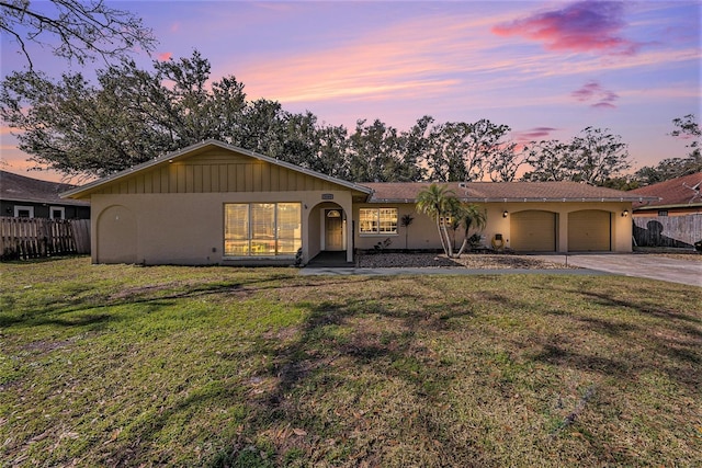 ranch-style house with a garage and a yard