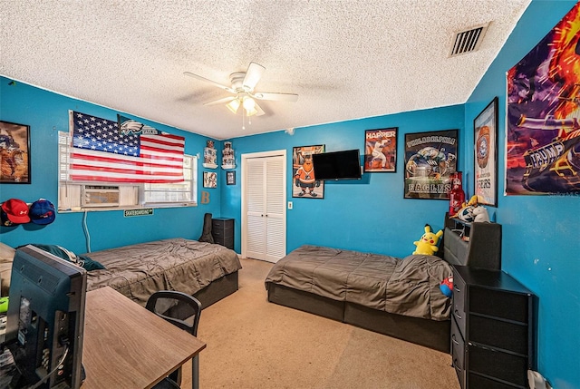 bedroom with carpet floors, cooling unit, ceiling fan, a textured ceiling, and a closet