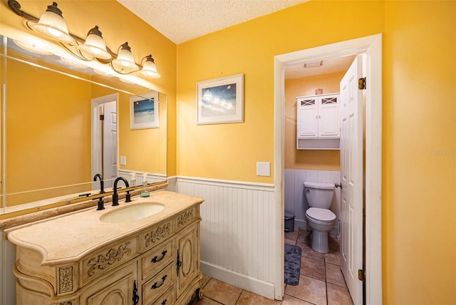 bathroom featuring vanity, tile patterned floors, toilet, and a textured ceiling